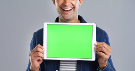 Tablet, man and green screen with mockup in studio, UI advertising or website ads for blog. Hands...