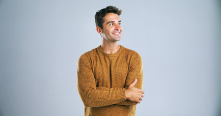 Smile, man and pride for fashion in studio with winter jersey, casual clothes and cool style. Mockup space, thinking and person with arms crossed for confidence, trendy outfit and white backgroundの写真素材