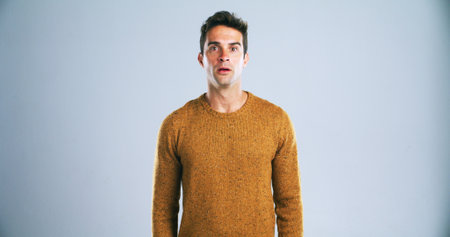 Portrait, man and shocked with reaction in studio for bad news, drama and gossip revelation. Mockup space, person and surprise expression for story, hearing rumor and announcement on white backgroundの写真素材