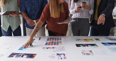Creative, meeting and hands of business people with color palette for planning, web design and ideas. Collaboration, teamwork and workers with tablet, documents and layout for company websiteの写真素材