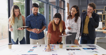 Team, creative business people and discussion with paper for brand strategist with tablet. Group,...