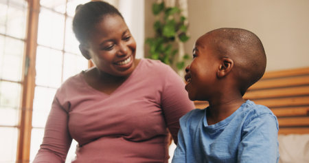 Home, black family and mother with boy, conversation and bonding together in bedroom. African parent, mama and son with discussion, smile and happiness with love, chatting and break with childの写真素材