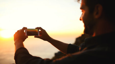 Man, hands and phone with sunset for picture, photography or capture moment on outdoor adventure....