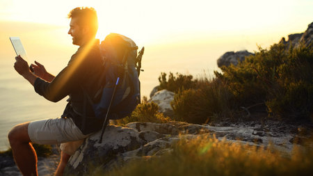 Man, hiking and mountain with search on with tablet, ocean or sunset with digital map in summer....