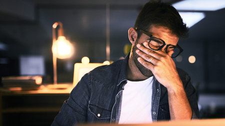 Tired, overworked and man with laptop, night or web designer with color sensitivity, sore or vision....