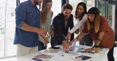 Office, business people and teamwork with pointing for color swatch, creative agency or talking. Boardroom, women or men as graphic designer with palette for brainstorming, company branding or choiceの写真素材