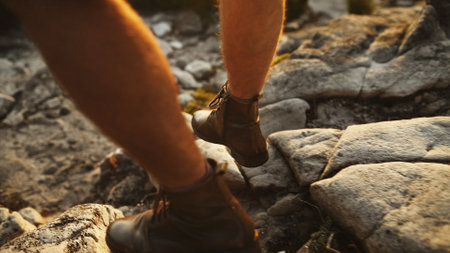 Legs, person and hiking by rocks for travel, vacation trip and holiday on adventure in nature. Walking, shoes and hiker trekking on mountain for exploration, tourism and journey for hobby outdoorの写真素材