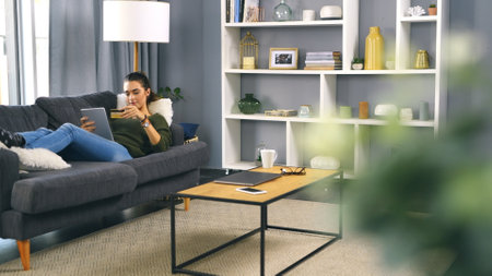 Home, woman and tablet with credit card for online shopping, banking app and password on couch. House, female person and smile with technology for debit pin, ecommerce and payment on sofa in loungeの写真素材