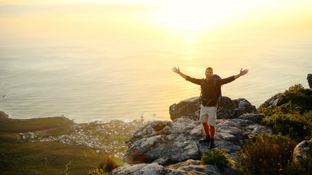 Ocean, mountains and man with open arms, sunset and excited with fitness, challenge and nature....