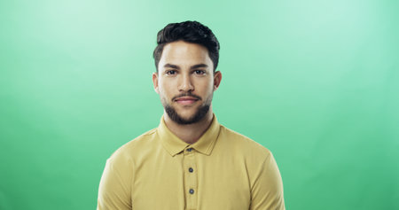 Smile, man and portrait of teacher in studio with confidence for career growth in education. Happy, mockup space and sports educator from brazil with pride for high school job by green background.の写真素材