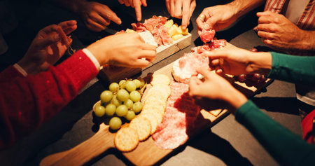 Charcuterie board, hands and food with people in home for celebration, eating or social gathering....