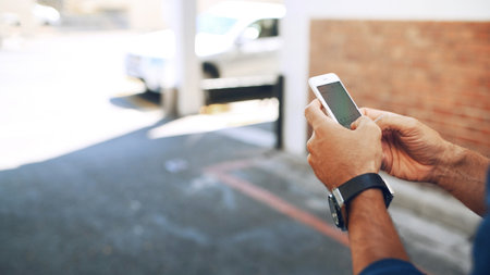 Phone screen, hands and person in city for travel, navigation app or search destination online. Mobile display, network and man outdoor for chat, text location or typing message on street with spaceの写真素材