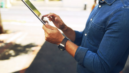 Man, hands and browsing with tablet in city street for research, social media or communication. Male person, scrolling and connection with technology for network, news or UI app in urban townの写真素材