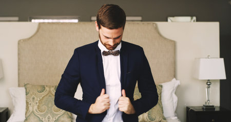 Man, groom and getting ready with suit for wedding preparation, engagement or ceremony at home. Male...