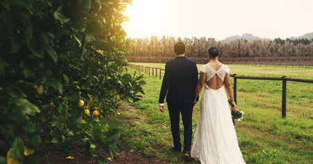 Love, wedding and couple holding hands in vineyard for celebration, commitment or romance. People, back of bride and groom in countryside for outdoor reception, special event or ceremony with loyaltyの写真素材