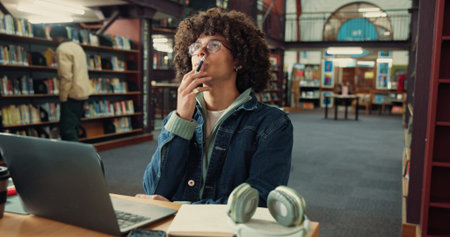 Thinking, student and man with laptop, library and idea for assignment on web, online or reflection....