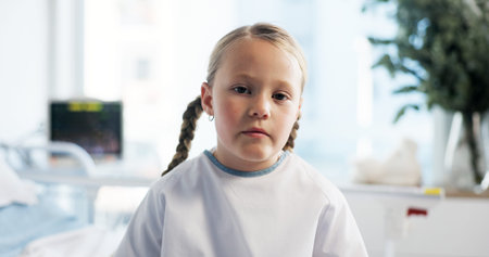 Girl, child and sick in portrait at hospital for recovery, treatment or pediatric service for wellness. Kid, face and patient with illness, tired and rehabilitation with health at clinic in Franceの写真素材