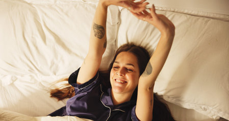 Above, smile and woman stretching in bed from sleeping, wake up and morning routine to start day....