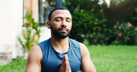 Man, yoga and meditation at house outdoor for zen, spiritual healing and mindfulness. Male person, namaste pose and pilates for inner peace, breathing exercise and balance for mental health on lawnの写真素材