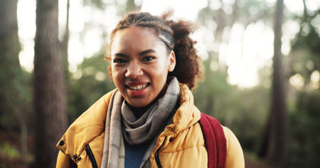 African woman, smile and hiking in forest with portrait, pride and adventure with backpack on trail. Person, girl and happy for trekking in woods, outdoor and explore with confidence in Nigeriaの写真素材