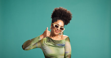 Thumbs up, fashion and happy woman in studio with sunglasses, approval and vote for agreement....