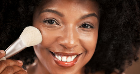 Makeup brush, happy and portrait of black woman in studio for cosmetics, foundation and skincare. Cosmetology, beauty and face of African person with tools to apply products, shine and makeoverの写真素材