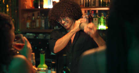 Bartender, man and shaker with people at nightclub for drinks with bottle service, skills and liquor for event. Person, barman and happy with patron for mixing, alcohol or spirits for cocktail at pubの写真素材