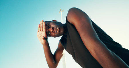 Tired, fitness and black man by blue sky for running, workout or training for marathon with break....