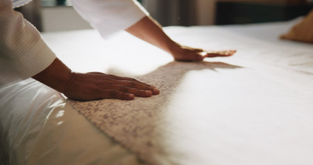 Cleaning, hands and blanket with person and bed for housekeeping, dusting and hospitality. Mattress, fabric and duvet bedding with closeup of cleaner in bedroom of hotel for hygiene, tidy and choresの写真素材