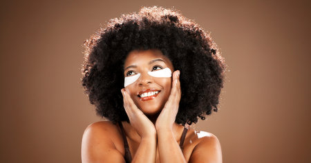 Eye mask, beauty and black woman in studio thinking for dark circles, hydration and wellness....