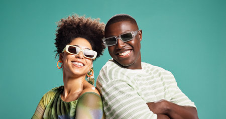Fashion, arms crossed and couple or people in studio for style, sunglasses and support. Happiness, trendy and clothes pride with African man and woman on green background for love and eyewearの写真素材