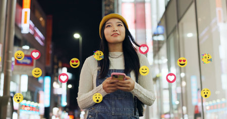 City, emoji and phone with asian woman at night for online interaction with social media followers....