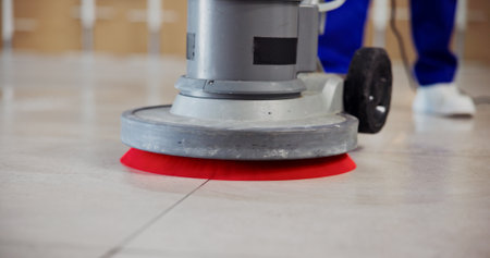 Janitor, feet and polishing machine on floor for cleaning tiles, office maintenance and hygiene. Cleaner, person and scrubbing equipment at workplace for dirt removal, surface grime or interior shineの写真素材