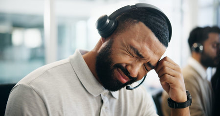 Burnout, headache and stress with man in call center for help or solution as virtual assistant....