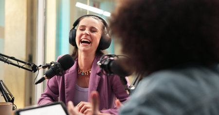 Laugh, mic and woman with guest for podcast, interview and discussion for content creation. Influencer, live streaming and host with person for funny conversation, chat and broadcast for talk showの写真素材