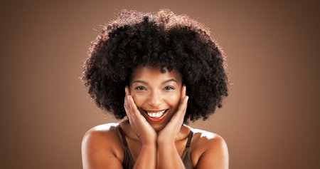Skincare, woman and portrait with beauty in studio with natural makeup, hydration glow or results. Mockup, smile and african person with self care for healthy skin and anti aging on brown backgroundの写真素材