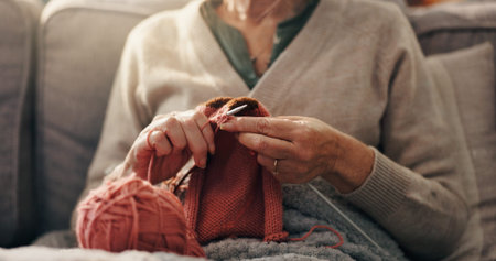 Senior woman, hands and knit on sofa for retirement hobby, cognitive stimulation or creativity....