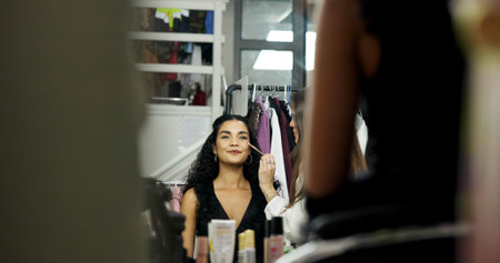 Woman, model or makeup artist in mirror for beauty, touch up or preparation for production. Behind...