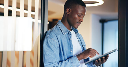 Business, tablet and black man in office, internet and research for web design. African person, employee and consultant in workplace, tech or digital app with creativity, online reading or connectionの写真素材