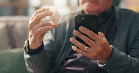 Hands, pills and phone on sofa with search for prescription, ingredients or label for side effects. Senior person, medicine bottle and smartphone on mobile app, online shopping or retirement in homeの写真素材