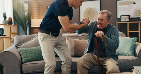 Senior man, caregiver or help with walking stick on sofa for mobility, assistance or fibromyalgia. Health worker, old person or support with cane in nursing home for injury recovery or rehabilitationの写真素材