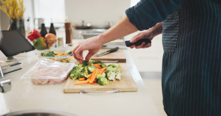 Food, hands and person cutting vegetables in home for cooking healthy dinner, meal or supper for diet. Knife, groceries and chef chopping ingredients for wellness, nutrition or recipe in kitchen.の写真素材