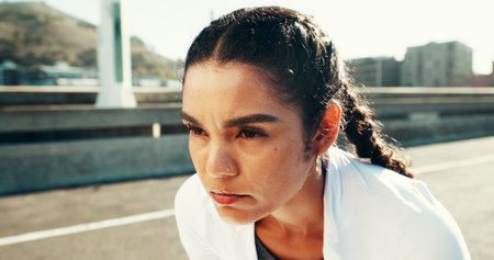 Fitness, fatigue and woman resting in city for health, wellness or exhausted with intense cardio. Runner, tired or relax on break outdoor for exercise, training challenge or think of workout recoveryの写真素材