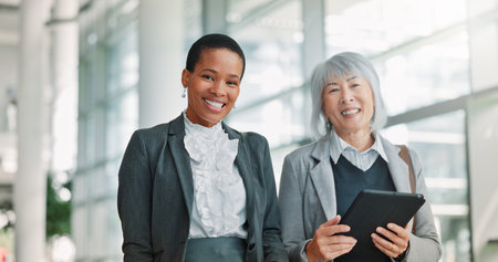 Hallway, tablet and women with collaboration, portrait and online investment with inflation analysis. Teamwork, people or financial advisors in office, tech or digital app for economy report or smileの写真素材
