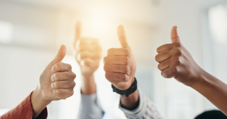 Thumbs up, collaboration or hands of business people for agreement, support or teamwork in office. Group approval, diversity or workers with gesture, emoji and yes sign for winner or success at flareの写真素材