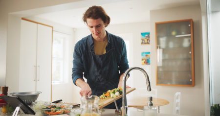 Man, tablet and cooking with meal prep, recipe tutorial or online guide in home. Learning, video instructions and person in kitchen with lunch ingredients, diet salad and internet steps for web blogの写真素材