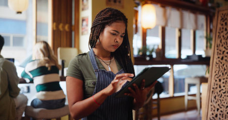 Woman, waitress and click with tablet at coffee shop for inventory, checklist or review at...