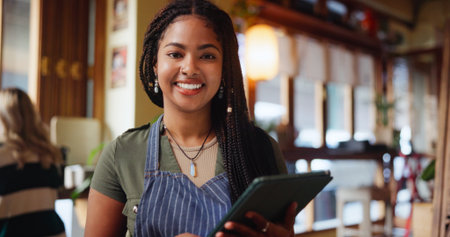 Woman, barista and portrait with tablet at cafe for inventory, checklist or smile at restaurant. Person, happy and small business owner with tech, application or report for stock at coffee shopの写真素材