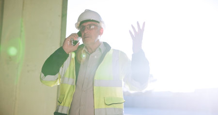 Construction, man or stress with phone call on site for building inspection fail, issue or feedback. Engineering, mature person and speaking to contractor for project management, safety risk or flareの写真素材