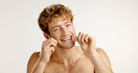 Oral care, floss and portrait of man in studio with hygiene, wellness and mouth routine. Dental...